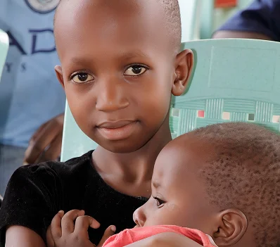 A girl holding a younger child